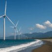 A row of towering white wind turbines along the Bangui coastline in Ilocos Norte, with turquoise waters, gentle waves, and mountain ranges beneath a clear blue sky.