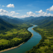 Aerial view of Cagayan Valley showing a winding turquoise river surrounded by green mountains, rice fields, and scattered rural settlements under a bright blue sky.