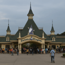 Photorealistic view of Enchanted Kingdom’s main entrance in Santa Rosa, Laguna, showing the Victorian-style gateway, green turrets, and crowds of visitors.